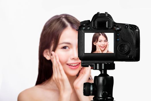 Asian American beauty vlogger creating content for social media vlog, behind camera shot