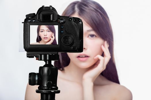 Asian American beauty vlogger creating content for social media vlog, behind camera shot