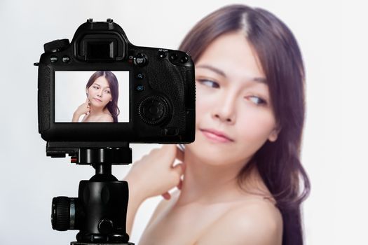 Asian American beauty vlogger creating content for social media vlog, behind camera shot