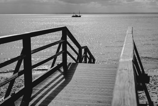 Wooden bridge for walks to the beach, black & white