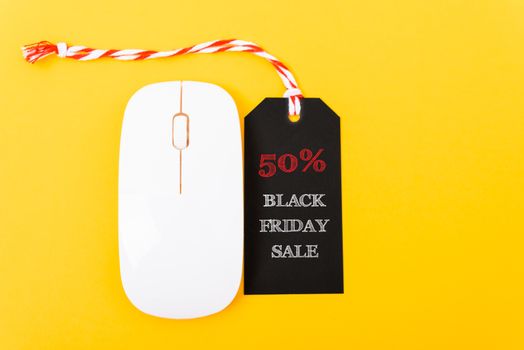 Online shopping Black Friday sale text red tag on white mouse with yellow background