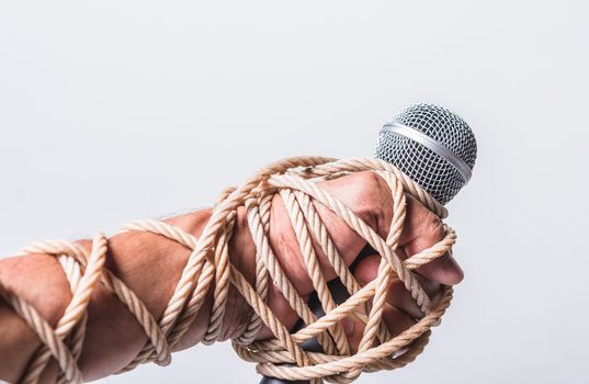 Hand holding microphone and have roped on fist hand on white background, Human rights day concept