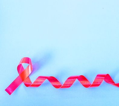 Red Ribbon Support HIV, AIDS on blue background and copy space for use
