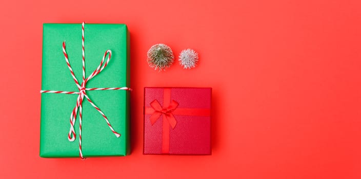 New Year, Christmas Xmas holiday composition, Top view green and red gift box and green fir tree branch on red background with copy space