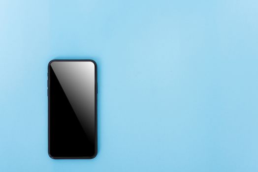 Top view of modern technology smart phone mobile on blue background with copy space
