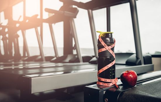 line tape centimeter wrapped around whey bottle at fitness gym