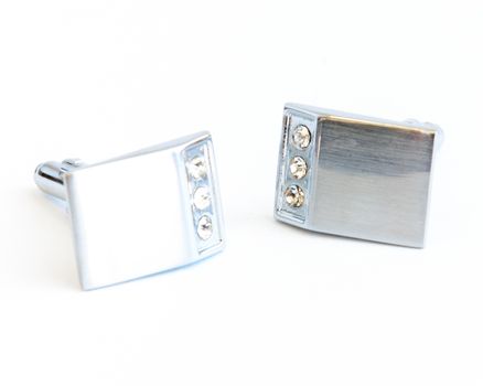 Close-up single pair of modern stainless steel cufflinks isolated on white background. Lifestyle trendy clothing accessories dress with clipping path and copy space.