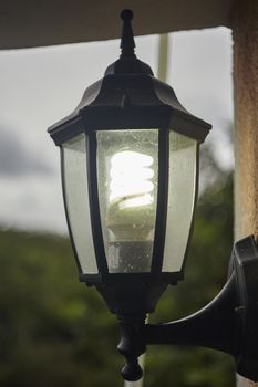 Outdoor lamp with light bulb dirty and damaged by the weather