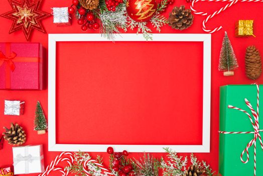 Christmas composition decorations, fir tree branches with Photo square frame on red background. Merry Christmas concept. Copy space for text