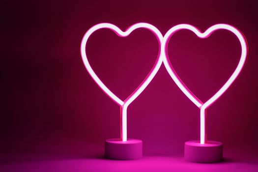 Two glowing pink neon hearts Valentines day party concept