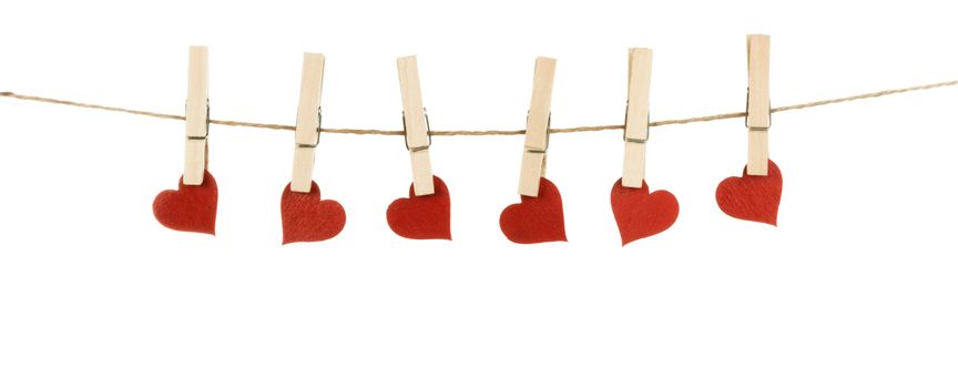 Clothes pegs and red wooden hearts on rope isolated on white background. Valentines day concept
