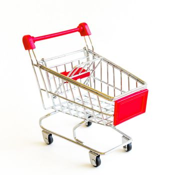 Small shopping cart isolated on white background. Tiny silver and red metallic empty push cart. Concept for online shopping and e-commerce.