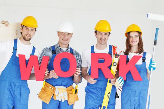Portrait of happy smiling construction workers team with red work letters