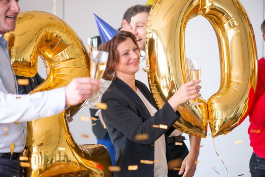 Business people are celebrating holiday in modern office drinking champagne and having fun in coworking. Merry Christmas and Happy New Year 2020 concept