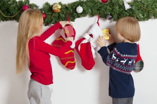Adorable little children open their stocking gifts on Christmas morning
