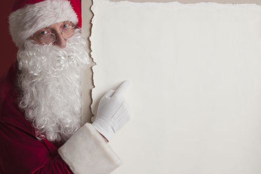 Santa Claus holding vintage paper billboard with copy space for text