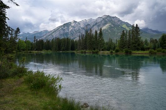Panoramic image of the tranquil Bow river close to Banff with cloudy sky, Banff National Park, Alberta, Canada