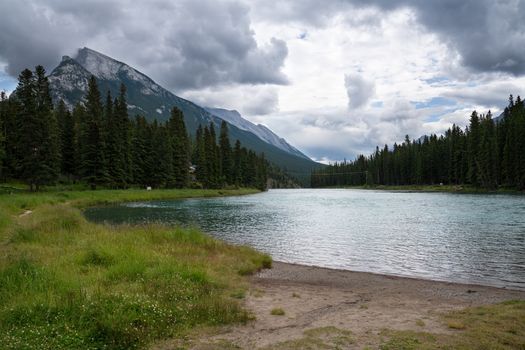 Panoramic image of the tranquil Bow river close to Banff with cloudy sky, Banff National Park, Alberta, Canada