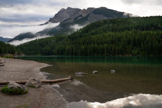 Panoramic image of mountain peak reflecting in Two Jack Lake with early morning mood, Banff National Park, Alberta, Canada
