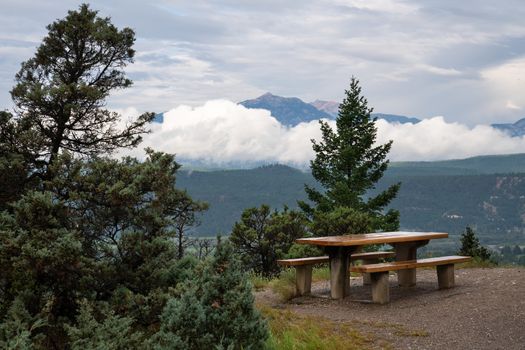 Panoramic image of a bench with the mountain range of the Kootenay National Park in the background, British Columbia, Canada
