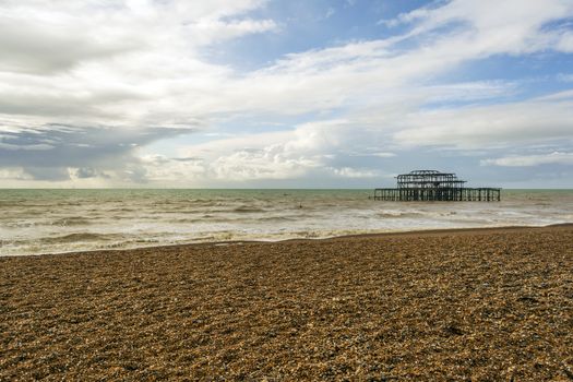 Panoramic view of Brighton's beach. In the background they are the remains of Brighton West Pier in sea. UK.