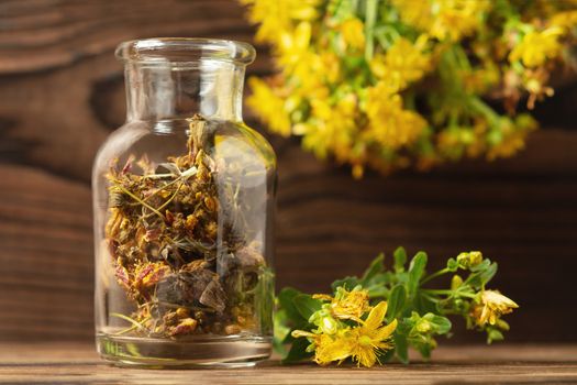 Concept of homeopathy and herbal treatment - dried Hypericum perforatum know as tutsan or Saint-Johns-wort in a bottle.