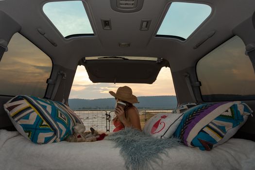 Woman on a road trip with her van takes a coffee break