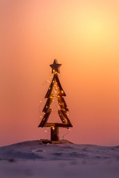 A simple Christmas tree with sparkling fairy lights on the beach at Christmas.  Australian Christmas.  Summer Christmas.  Space for copy