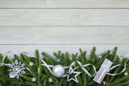 Christmas new year flat lay bauble decor and fir branches on white toned natural wooden plank background texture provence style with copy space for text