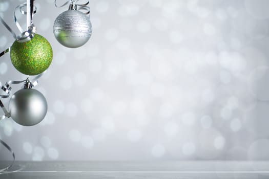 Silver and red Christmas new year balls with curly streamer ribbon bow over glittering bokeh lights background with copy space for text