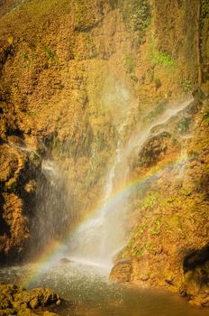 Cool refreshing waterfall pouring into an emerald pond and rainbow over Dai Yem (Pink Blouse) waterfall in Muong Sang, Moc Chau, Son La, Vietnam. Fall gushes down its slope limestone