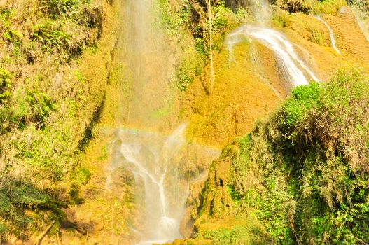 Close-up spectacular view of fall gushes down its slope, white curtain flowing in Dai Yem (Pink Blouse) waterfall, Moc Chau, Son La, Vietnam. Cool refreshing spring pouring on limestone wall, poetic scene