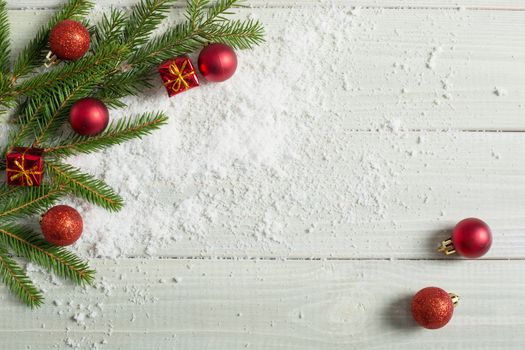 Light white toned natural wooden plank background with fir and christmas decorative baubles