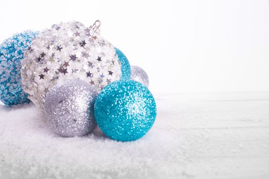 Christmas decoration of colorful glitter balls on wooden background with copy space for text new year card concept isolated on white