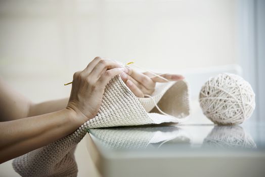 Woman's hands doing home knitting work - people with DIY work at home concept