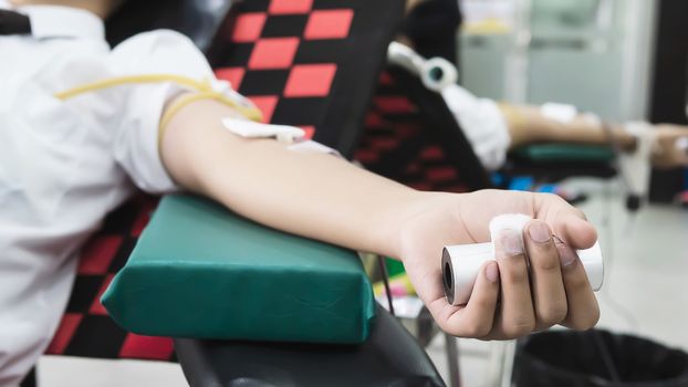 Volunteer man giving blood donation to cross red organisation - people with blood donation concept