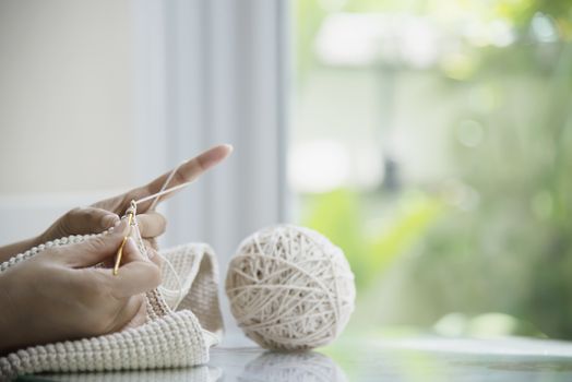 Woman's hands doing home knitting work - people with DIY work at home concept