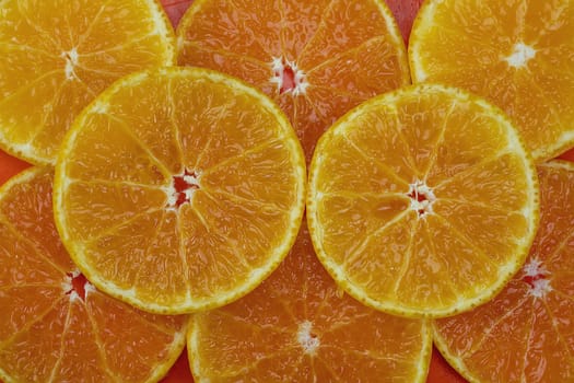 Fresh sliced juicy orange fruit set over orange background - tropical orange fruit texture for background use