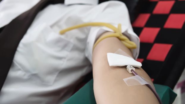 Volunteer man giving blood donation to cross red organisation - people with blood donation concept