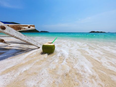 Relax beach chair with fresh coconut on clean sand beach with blue sea and clear sky - sea nature background relax concept