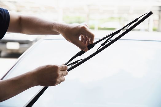 Man doing car wiper cleaning or changing maintenance - people with car maintenance concept