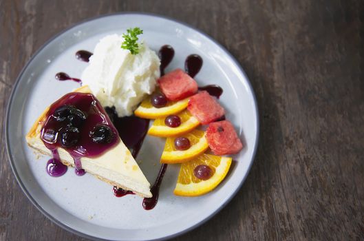 Colorful New York cheese cake with well decorated fruit pieces and whipped cream in white plate - cake recipe menu concept