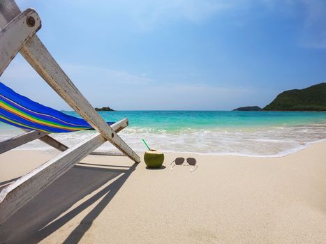 Relax beach chair with fresh coconut on clean sand beach with blue sea and clear sky - sea nature background relax concept