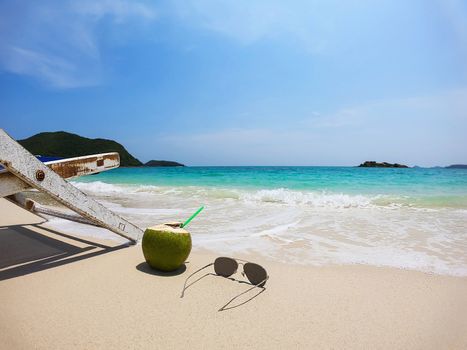 Relax beach chair with fresh coconut on clean sand beach with blue sea and clear sky - sea nature background relax concept