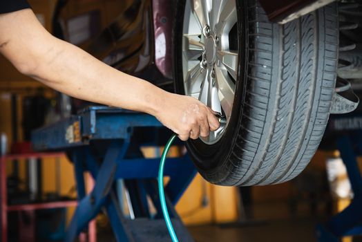 Technician is inflate car tire - car maintenance service transportation safety concept