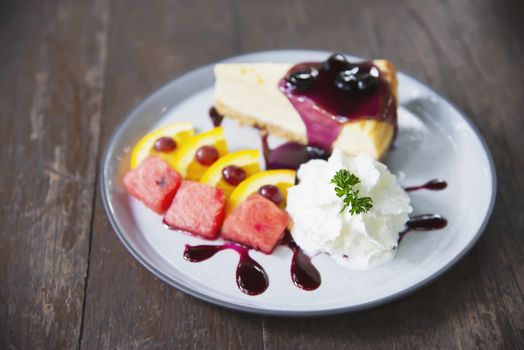 Colorful New York cheese cake with well decorated fruit pieces and whipped cream in white plate - cake recipe menu concept