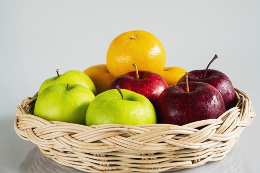 Fresh red green apple and orange over gray black background - fresh fruit background concept