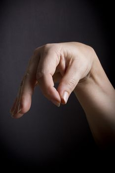 Female hand with closed fingers on a black background