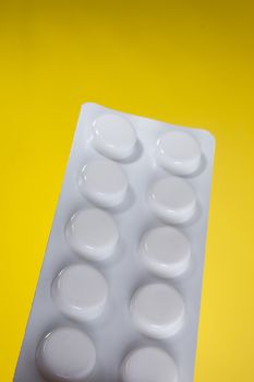 Blister with pills on a yellow background