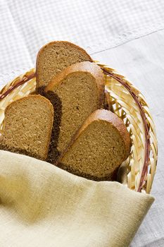 Sliced bread in a basket on a table covered with a linen tablecloth